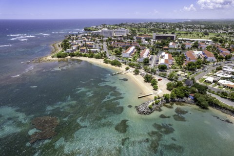 Aerial view of town along a beach with turquoise water.