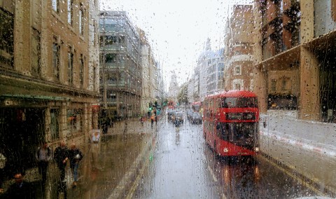 Image of a red double-decker bus on a rainy street.