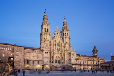 Image of ornate stone church illuminated at night with a plaza in front